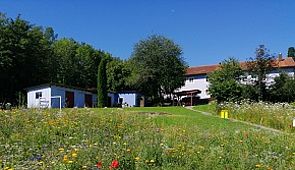 AWO Wohnheim Eichendorf - Das Bild zeigt das AWO Wohnheim Eichendorf mit einer wunderschönen Blumenwiese vor der Einrichtung.